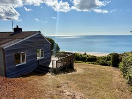 A house with a deck overlooking the sea at Beach Cove in Freshwater East, Pembrokeshire