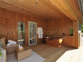 An outdoor area with a wooden bathtub and seating at The Hideout in Lanreath