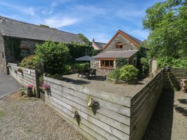 A house with a table and chairs under an umbrella at Barn Court Cottage in Narberth, Pembrokeshire