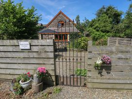 An entrance with a gate and flowers at Barn Court Cottage Narberth, Pembrokeshire