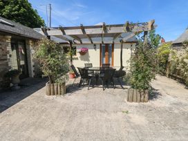 An outdoor area with a table and chairs under a pergola at Stoney Cottage, Narberth, Pembrokeshire