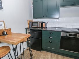 A kitchen with appliances and wooden furniture at Pengeulan Cemmaes