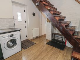 An entrance hall with a washing machine and staircase at Pengeulan in Cemmaes