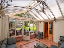 A conservatory with seating and a view of the garden at Weavers Cottage in Carlton-in-Cleveland near Stokesley