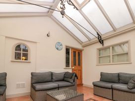 A conservatory with a sofa and coffee table at Weavers Cottage Carlton-in-Cleveland near Stokesley