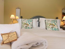 A bedroom with a bed and decorative pillows at Weavers Cottage in Carlton-in-Cleveland near Stokesley