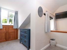 A bedroom with a wardrobe and a small TV at Weavers Cottage, Carlton-in-Cleveland near Stokesley