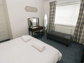A bedroom with a bed and vanity table at Cwtch Ar Y Mor Burry Port