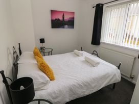 A bedroom with a bed and nightstand at Cwtch Ar Y Mor in Burry Port