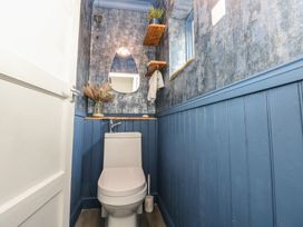 A bathroom with a toilet and mirror at Cwtch Ar Y Mor in Burry Port