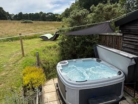An outdoor area with a hot tub and a hammock at Deer Lodge in Wimborne Minster
