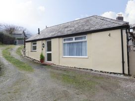 A single story house with a pitched roof along a gravel driveway at The Old Coach House in Penmaenmawr