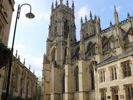 An exterior view of a Gothic cathedral with tall towers and arched windows in Pocklington