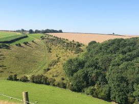A rural landscape with green fields trees and a path under a clear sky at 1 Church Barns in Pocklington