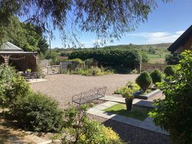 An outdoor space with a gravel area and flower pots at Larchwood Lodge, Ellon