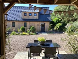 An outdoor area with a table and chairs in front of a wooden building at Larchwood Lodge in Ellon
