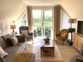 A living room with a sofa, armchair, and coffee table at Larchwood Lodge in Ellon