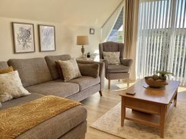 A living room with a sofa and armchair at Larchwood Lodge in Ellon
