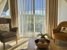 A living room with two armchairs and a table at Larchwood Lodge in Ellon