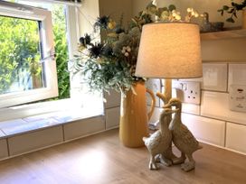 A kitchen with a lamp and flowers on the countertop at Larchwood Lodge in Ellon