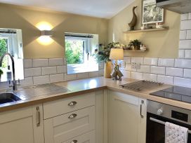 A kitchen featuring a sink, stove, and decorative items at Larchwood Lodge in Ellon