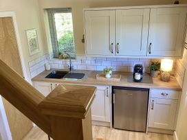 A kitchen with sink, cabinets, and coffee maker at Larchwood Lodge in Ellon