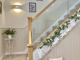 A stairway with a glass railing and decorative plant at Larchwood Lodge in Ellon