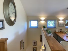 A view of a room with a clock and shelves at Larchwood Lodge in Ellon