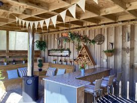 A garden room with seating and a bar area at Larchwood Lodge in Ellon