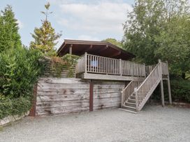 A wooden cabin with a deck and stairs at Sunny View in Rhayader