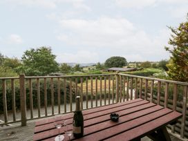 An outdoor patio with a table, champagne, and glasses at Sunny View in Rhayader