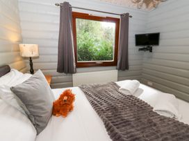 A bedroom with a bed, lamp, and television at Sunny View in Rhayader