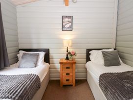 A bedroom with two beds and a nightstand at Sunny View in Rhayader