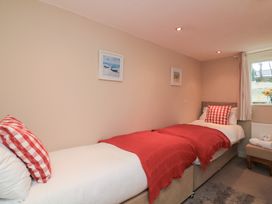 A bedroom with two beds and paintings at Lanapoule in Salcombe