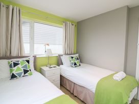 A bedroom with two beds and a lamp at Lanapoule in Salcombe