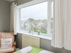 A bedroom with a window and chair at Lanapoule in Salcombe