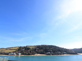 A waterfront view with hills and houses at Lanapoule Salcombe