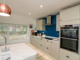 A kitchen with cabinets, sink, oven and kettle at Lanapoule in Salcombe