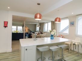 A kitchen with an island and bar stools at Lanapoule, Salcombe