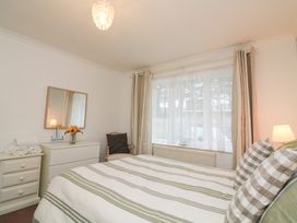 A bedroom with a bed and a dresser at Lanapoule in Salcombe