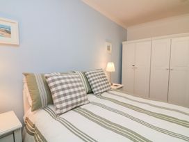 A bedroom with a bed and wardrobe at Lanapoule in Salcombe