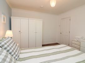 A bedroom with a bed and wardrobe at Lanapoule in Salcombe