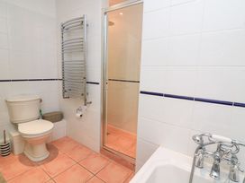 A bathroom with a shower, bathtub, toilet, and towel radiator at Lanapoule Salcombe