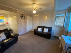 A living room with a sofa, armchair and clock at 246 California Road, California, Norfolk