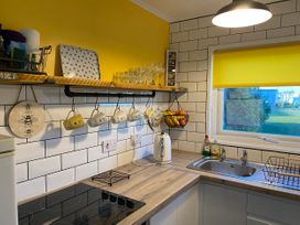 A kitchen with utensils on shelves and a window view at 246 California Road, California, Norfolk
