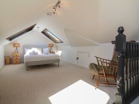 A bedroom with a bed and chair at Auverne Poundstock near Widemouth Bay