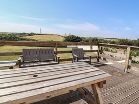 An outdoor area with wooden table and chairs at Auverne Poundstock near Widemouth Bay