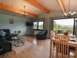 A living room with a sofa and dining table at Mountain View in Rhayader