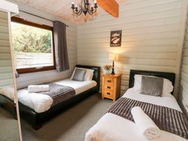 A bedroom with two beds and a nightstand at Mountain View in Rhayader