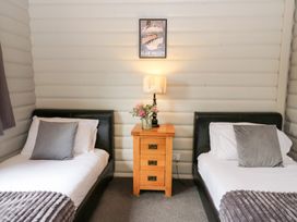 A bedroom with two beds and a nightstand at Mountain View in Rhayader